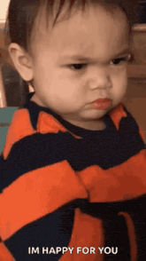 a baby is making an angry face with his arms crossed and says `` i 'm happy for you '' .