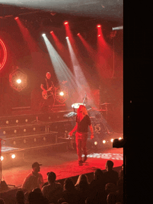 a man stands on stage in front of a drum set that says 15