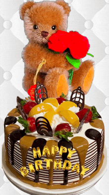 a teddy bear is holding a red rose on top of a birthday cake