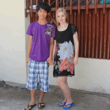 a man in a purple shirt and a woman in a black dress hold hands