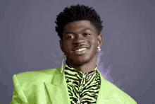 a man wearing a green jacket and a zebra print shirt smiles for the camera