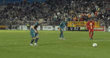 a blurry picture of a soccer game with a goalie getting ready to block a shot