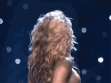 a woman with blonde hair and red lips is dancing on a stage .