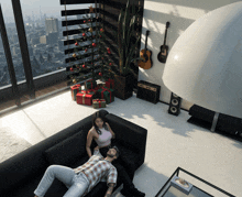 a man and woman sit on a couch in front of a christmas tree and guitars