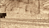 a train is on the tracks in front of a rock wall