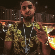 a man with a beard wearing a black shirt with gold coins on it