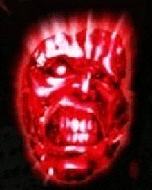 a close up of a red face with glowing eyes and teeth .