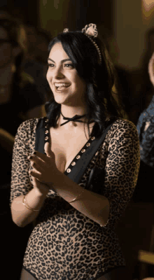 a woman in a leopard print bodysuit is smiling