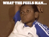 a young boy sitting on a couch with the words what the feels man