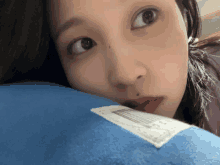 a close up of a woman 's face with a blue pillow