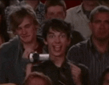 a group of people are sitting in a theatre and one of them is making a funny face