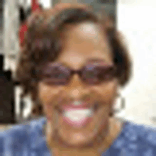 a woman wearing sunglasses is smiling for the camera .