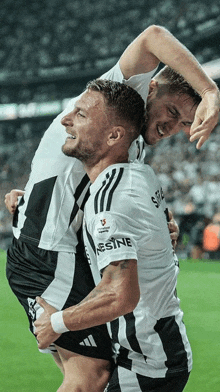 two soccer players are hugging each other with one wearing a shirt that says resine