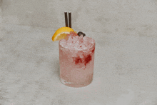 a pink cocktail with a lemon slice and straws