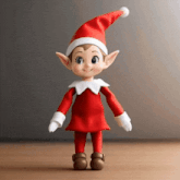 the elf on the shelf is wearing a santa hat and gloves