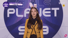 a girl wearing bunny ears is standing in front of a sign that says planet 999