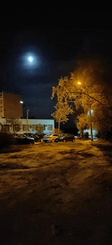 a full moon is visible over a parking lot