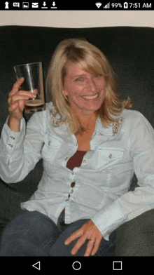 a woman sitting on a couch with a glass in her hand