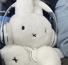 a stuffed bunny wearing headphones has an x on its head