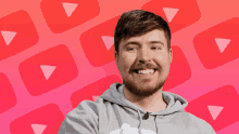 a man with a beard wearing a grey hoodie is smiling in front of a youtube logo