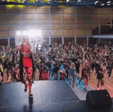 a woman stands on a stage in front of a crowd with a sign that says ' i love you '