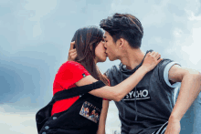 a man and woman kissing with the man wearing a psycho shirt