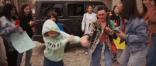 a group of people are holding hands in front of a black jeep while a girl holds a sign that says " freedom "