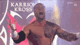 a shirtless wrestler with the name karrion kross on the back of his shirt