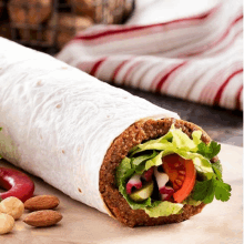 a tortilla wrap with lettuce tomatoes and almonds