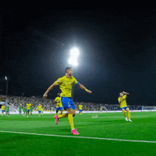 a soccer player wearing a yellow and blue jersey with the word adidas on it is running on the field