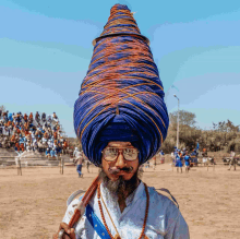 a man wearing glasses and a blue turban has the word chanel written on his face