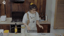 a woman in an apron is preparing food in a kitchen with a box of rice in front of her