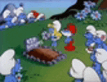 a group of smurfs are gathered in a grassy field .