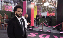 a man in a suit and tie stands in front of a sign that says ' say ' on it