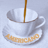 a cup of coffee on a saucer that says americano on it