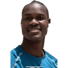 a man wearing a blue shirt is smiling with a white background