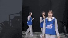 a girl wearing a blue vest that says ' aoyama ' on it
