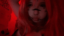 a woman with red hair and a mustache is wearing a cat costume and making a face .