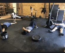 a group of people laying on the floor in a gym with a bucket that says ' gatorade ' on it