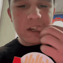 a man wearing a mcdonald 's t-shirt is eating french fries