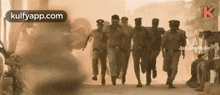 a group of police officers are running down a street in a sepia tone .