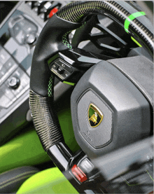 a lamborghini steering wheel with a green and yellow emblem