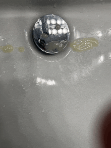 a close up of a sink with a drain and a faucet