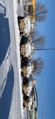 a row of military vehicles are parked on the side of a snowy street