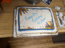 a birthday cake with blue frosting and sprinkles says happy 37th birthday melissa