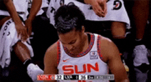 a female basketball player wearing a sun jersey