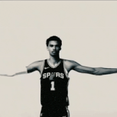 a man in a spurs jersey stands in front of a signature