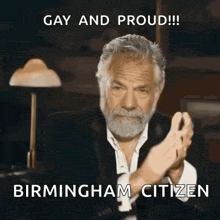 a man with a beard is clapping and saying gay and proud