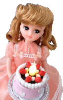 a doll in a pink dress is holding a small cake