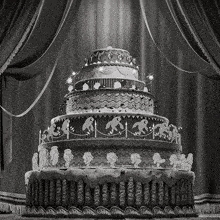 a black and white photo of a cake with monkeys and candles on it